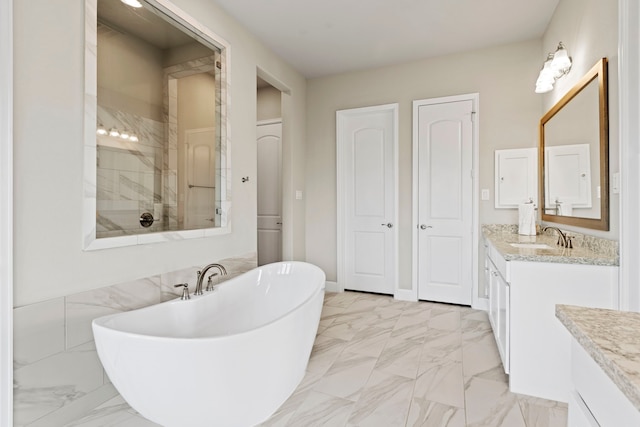 full bath with vanity, baseboards, a tile shower, a freestanding bath, and marble finish floor