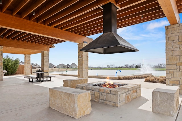 view of patio / terrace with an outdoor fire pit and a water view