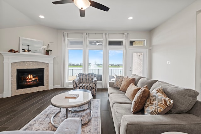 living area with a tiled fireplace, lofted ceiling, recessed lighting, wood finished floors, and a ceiling fan