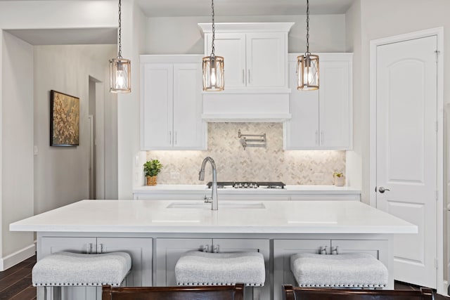 kitchen featuring decorative backsplash, white cabinetry, dark wood-type flooring, and light countertops