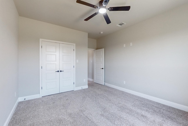 unfurnished bedroom with visible vents, baseboards, carpet flooring, a closet, and a ceiling fan