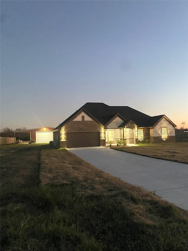 ranch-style house with driveway, an attached garage, and a yard