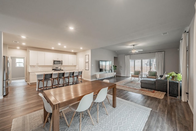 dining area with recessed lighting, dark wood-style flooring, and baseboards