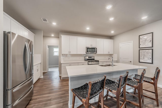 kitchen featuring recessed lighting, dark wood-style flooring, appliances with stainless steel finishes, and a sink