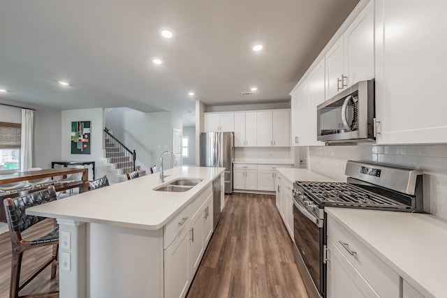 kitchen with light countertops, dark wood-style floors, appliances with stainless steel finishes, and a sink