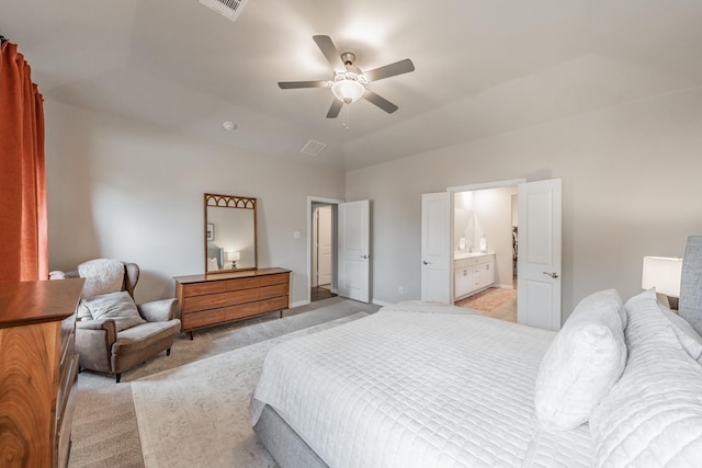 bedroom with light colored carpet, ensuite bathroom, lofted ceiling, and ceiling fan