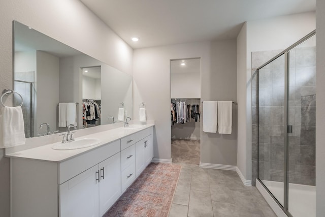 full bathroom featuring double vanity, a stall shower, and a sink