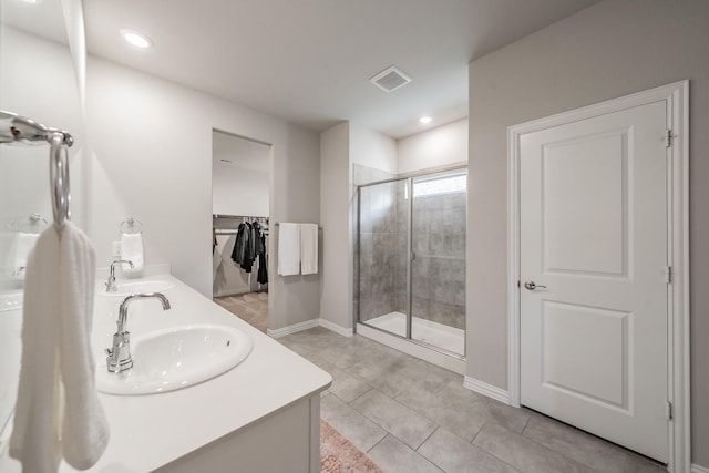 full bathroom featuring double vanity, visible vents, a shower stall, and a sink