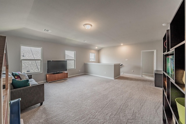 carpeted living area with lofted ceiling, baseboards, and visible vents