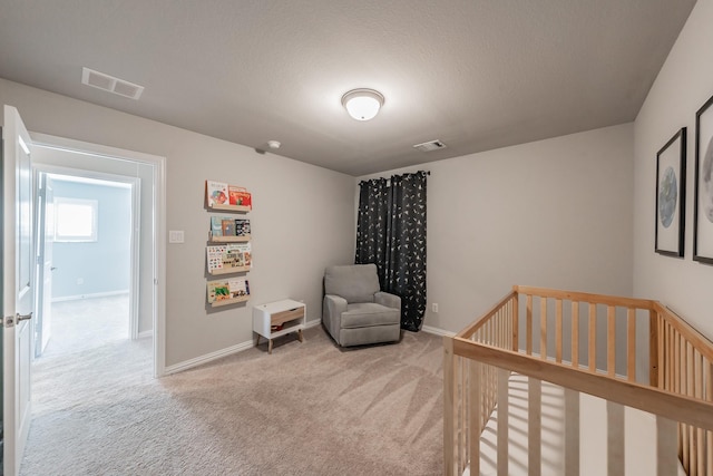 carpeted bedroom with visible vents, baseboards, and a crib