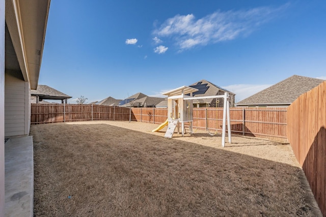 view of yard featuring a playground and a fenced backyard