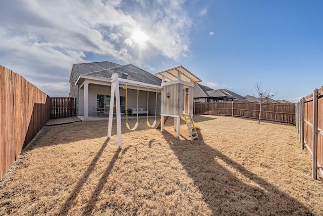 rear view of property with a fenced backyard and a patio area