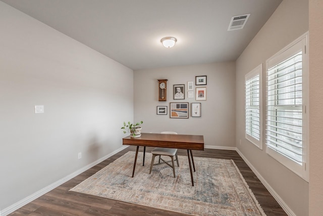 office space with visible vents, baseboards, and dark wood finished floors