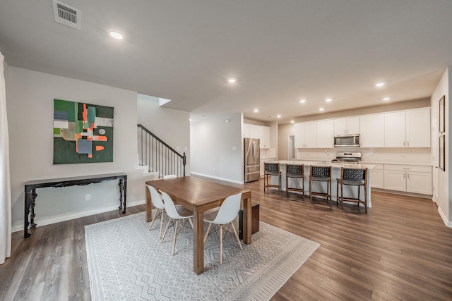 dining space with visible vents, dark wood finished floors, recessed lighting, stairway, and baseboards