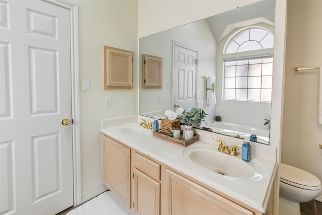 bathroom featuring double vanity, toilet, vaulted ceiling, and a sink