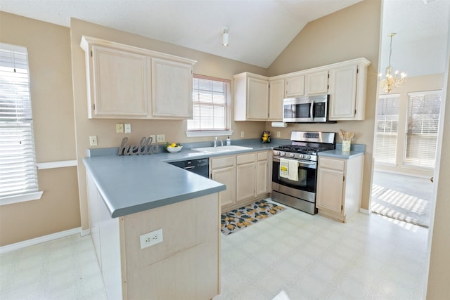 kitchen featuring light floors, a peninsula, a notable chandelier, stainless steel appliances, and a sink