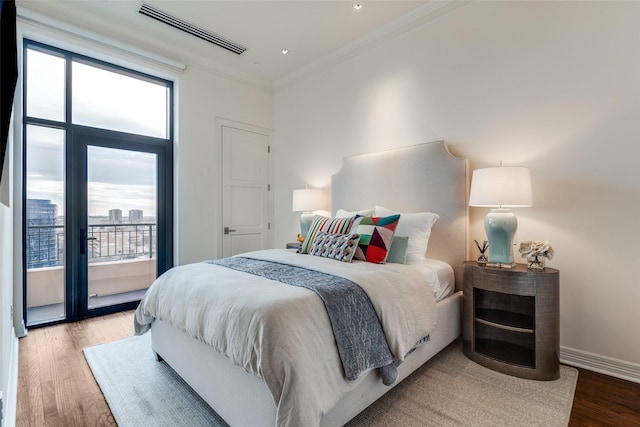 bedroom featuring visible vents, multiple windows, wood finished floors, and access to exterior