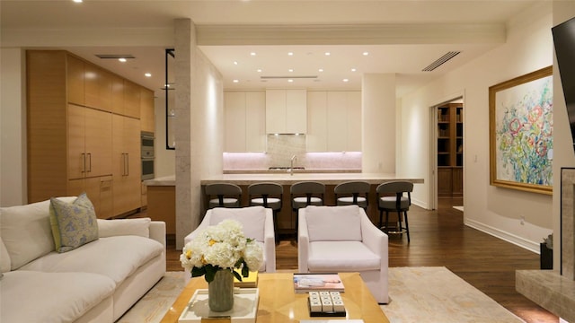 living room with visible vents, baseboards, ornamental molding, recessed lighting, and wood finished floors