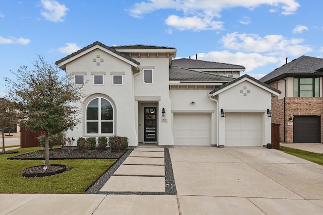 view of front of home featuring a front yard, driveway, an attached garage, stucco siding, and a tiled roof