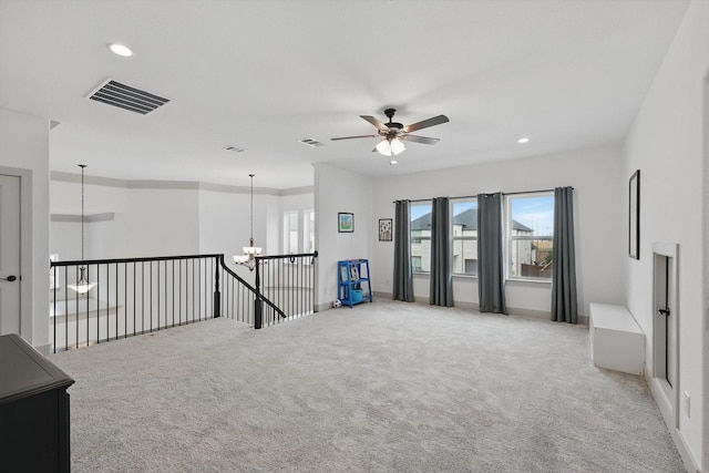 spare room featuring recessed lighting, carpet flooring, ceiling fan with notable chandelier, and visible vents