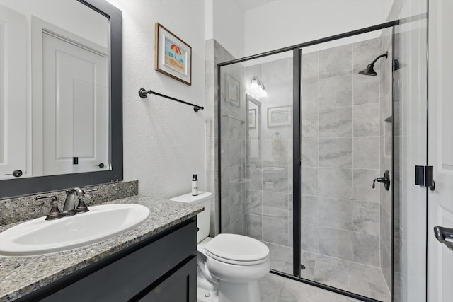 bathroom with vanity, toilet, and a stall shower