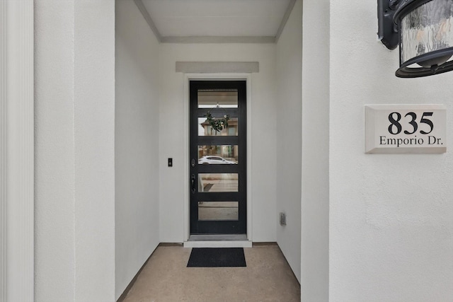 doorway to property featuring stucco siding