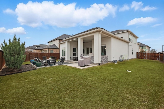 rear view of house with a patio area, stucco siding, a yard, and a fenced backyard