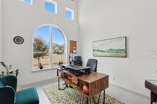 tiled office with a high ceiling and baseboards