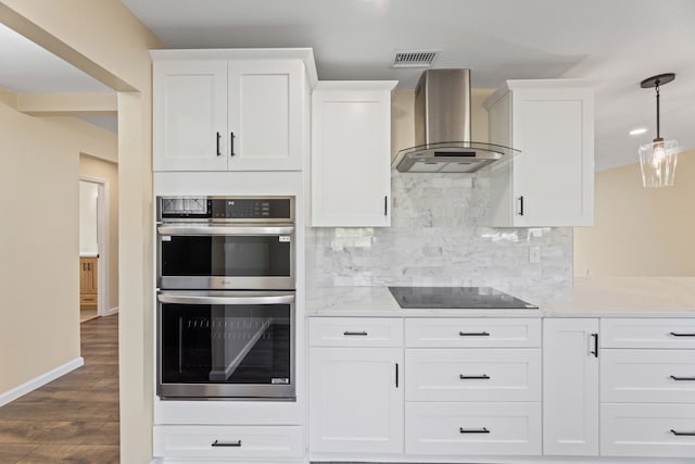 kitchen featuring visible vents, backsplash, wall chimney range hood, double oven, and black electric cooktop