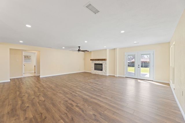 unfurnished living room featuring a ceiling fan, wood finished floors, visible vents, recessed lighting, and a fireplace