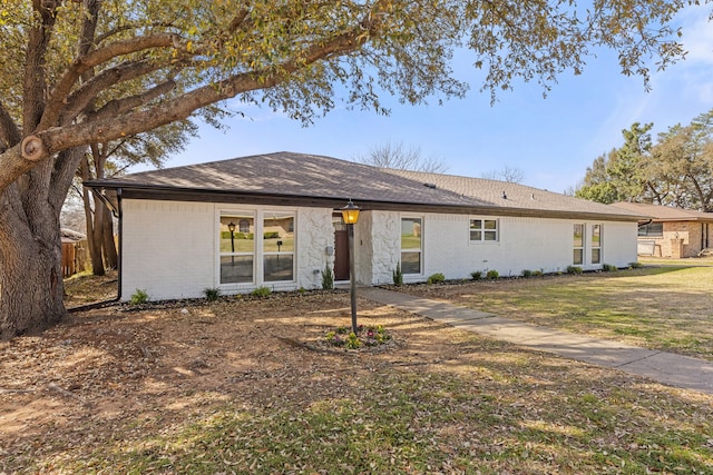 view of front of home featuring a front yard, fence, and brick siding