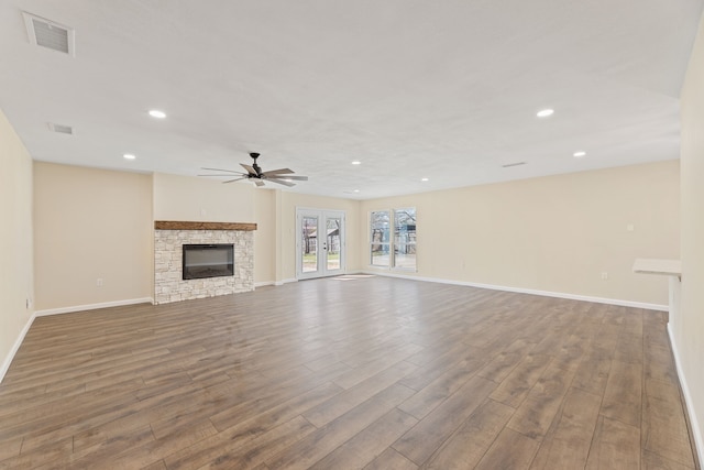 unfurnished living room with ceiling fan, visible vents, baseboards, and dark wood-style floors