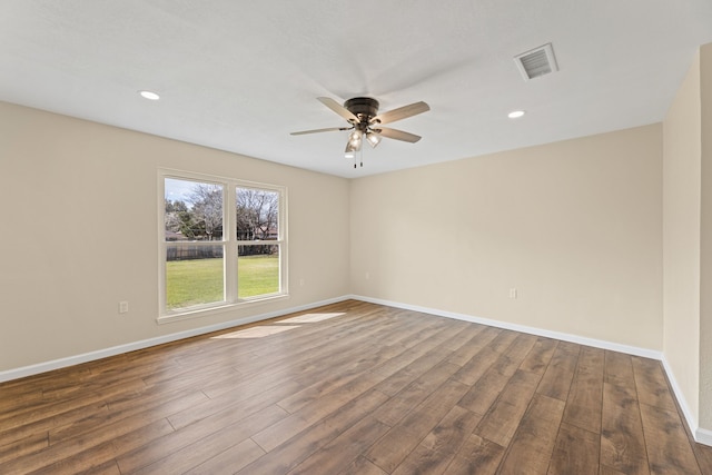 unfurnished room with dark wood finished floors, visible vents, baseboards, and a ceiling fan