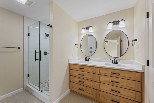 bathroom with tile patterned floors, baseboards, a stall shower, and a sink