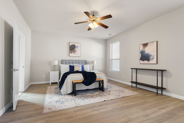 bedroom featuring ceiling fan, wood finished floors, visible vents, and baseboards