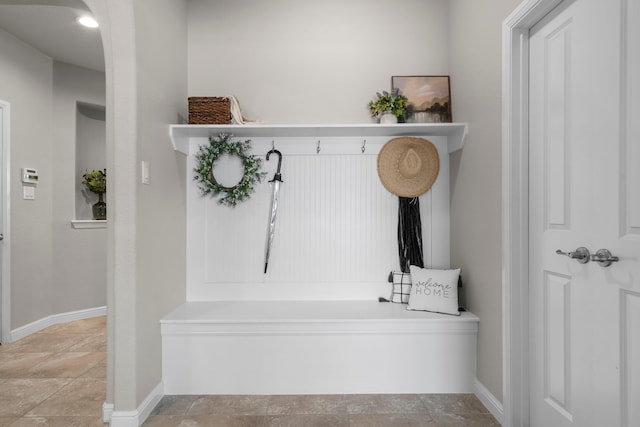 mudroom with stone finish flooring and baseboards