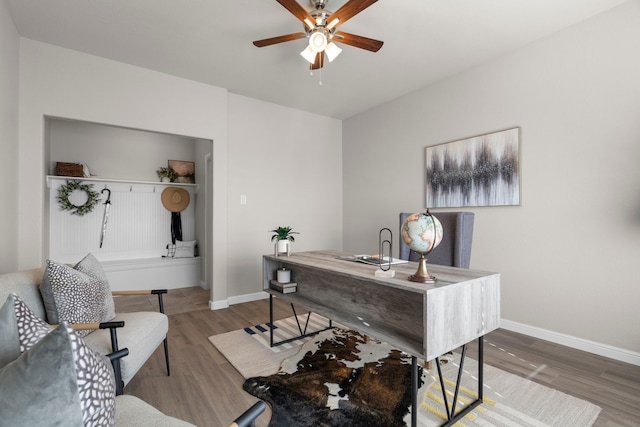 office featuring wood finished floors, a ceiling fan, and baseboards