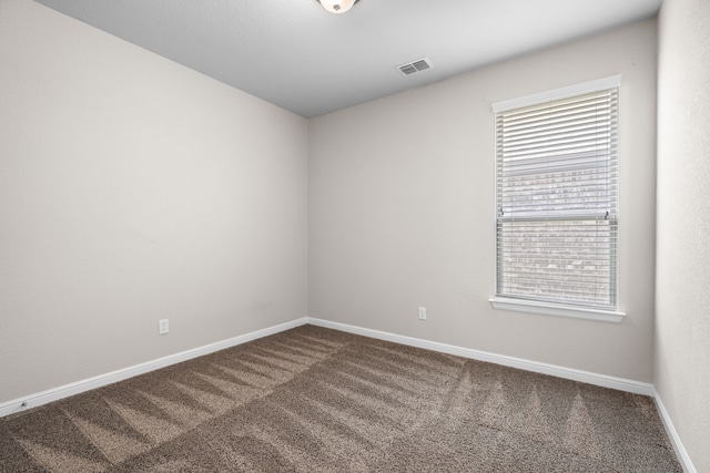 spare room featuring visible vents, baseboards, and carpet floors