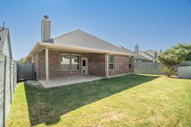 rear view of house with brick siding, a fenced backyard, a patio, and roof with shingles