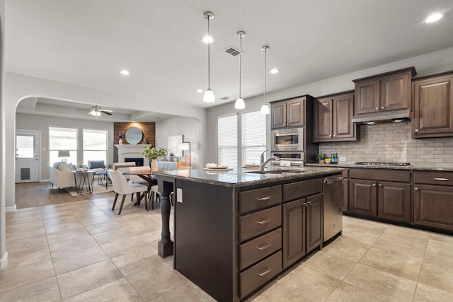 kitchen with visible vents, a sink, stainless steel appliances, arched walkways, and ceiling fan