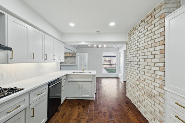 kitchen featuring tasteful backsplash, a peninsula, dark wood-style floors, black appliances, and a sink