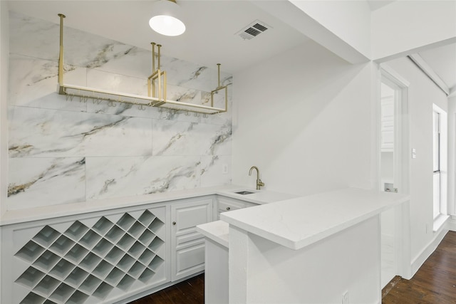 interior space with visible vents, a sink, dark wood finished floors, a peninsula, and open shelves