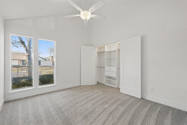 unfurnished bedroom with baseboards, carpet, ceiling fan, and high vaulted ceiling