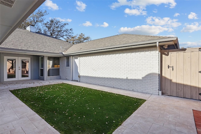 view of yard with a gate, french doors, a patio, and fence