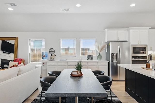 kitchen with a healthy amount of sunlight, appliances with stainless steel finishes, light countertops, and light wood-type flooring