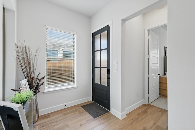 foyer entrance featuring light wood-style floors and baseboards