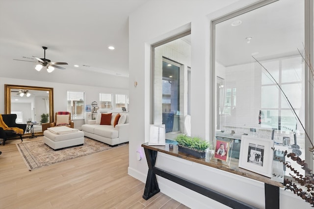 living area with recessed lighting, a ceiling fan, and wood finished floors