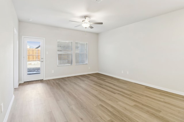 empty room featuring visible vents, baseboards, light wood-type flooring, and ceiling fan