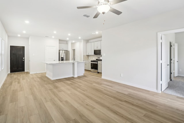 unfurnished living room with light wood finished floors, visible vents, baseboards, ceiling fan, and recessed lighting