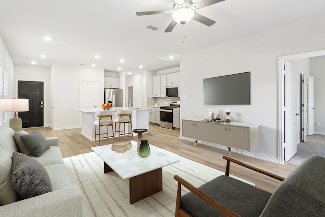 living area featuring recessed lighting, a ceiling fan, visible vents, and light wood-type flooring